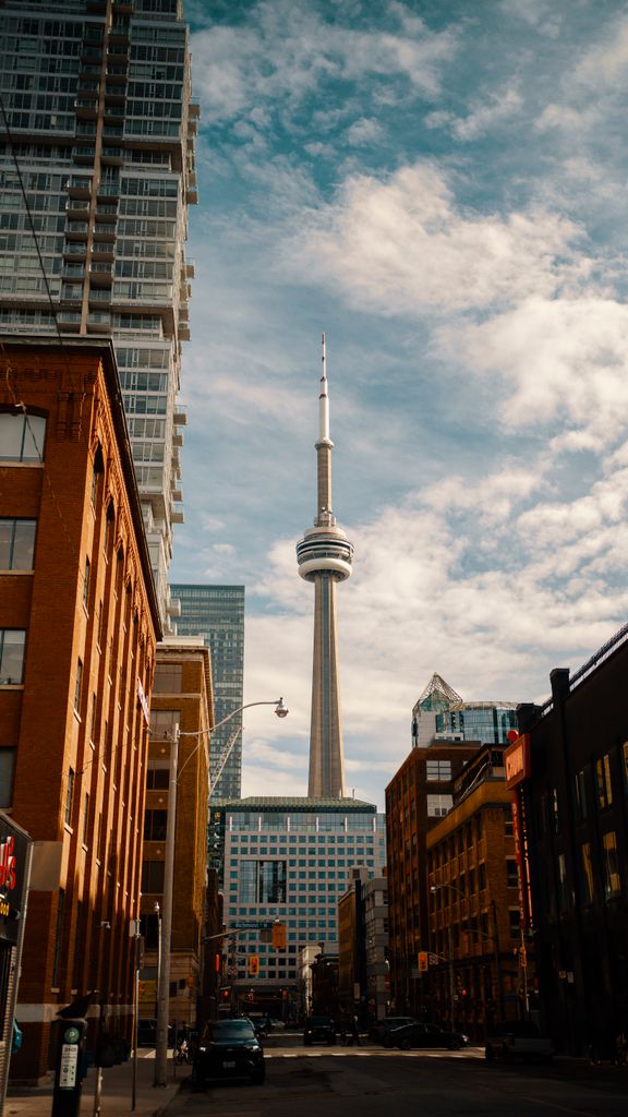 A vibrant view of downtown Toronto with the iconic CN Tower under a blue sky.