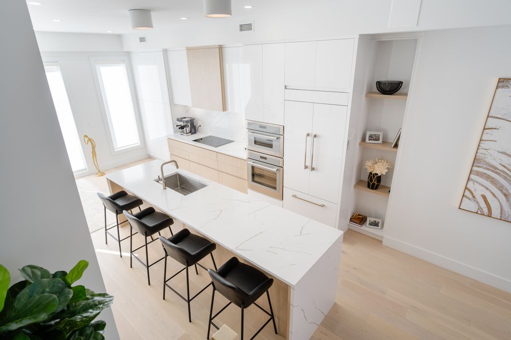 Bright and sleek modern kitchen featuring a marble countertop island and stylish bar stools for a clean look.